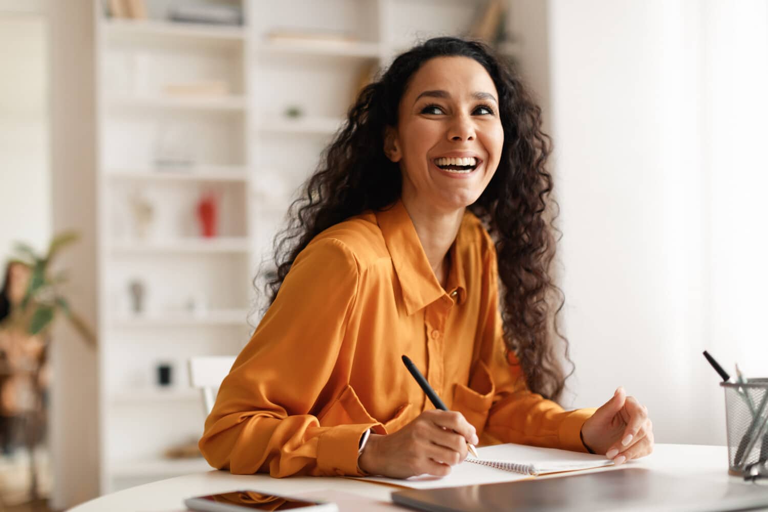 Woman taking notes and laughing