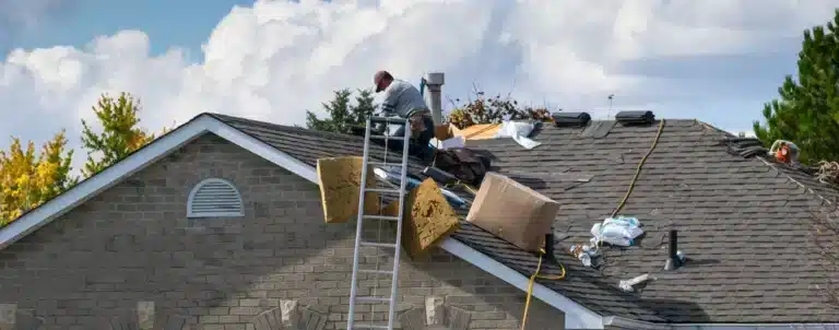 repairman on roof using proper tools to fix blown off shingles