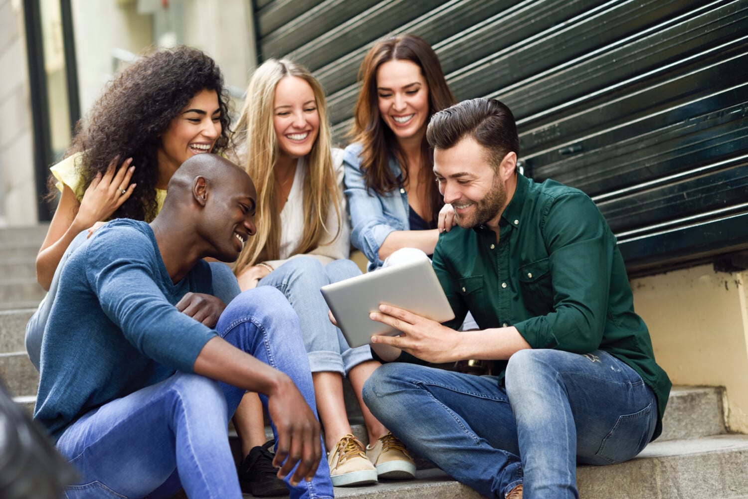 Multi-ethnic group of young people looking at a tablet computer
