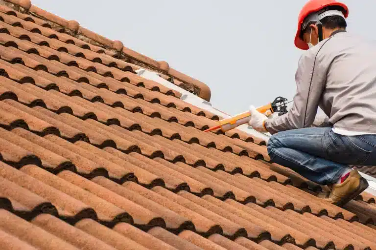 Roof leak repair cost-roofer sealing tiles
