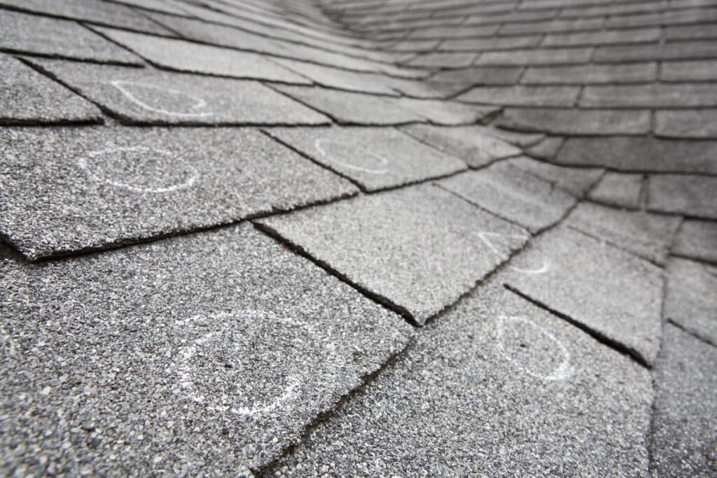 hail damage vs blistering-roof shingles showing where damage has occurred from hail