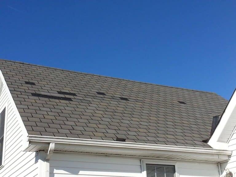 Roof missing shingles from a recent storm.